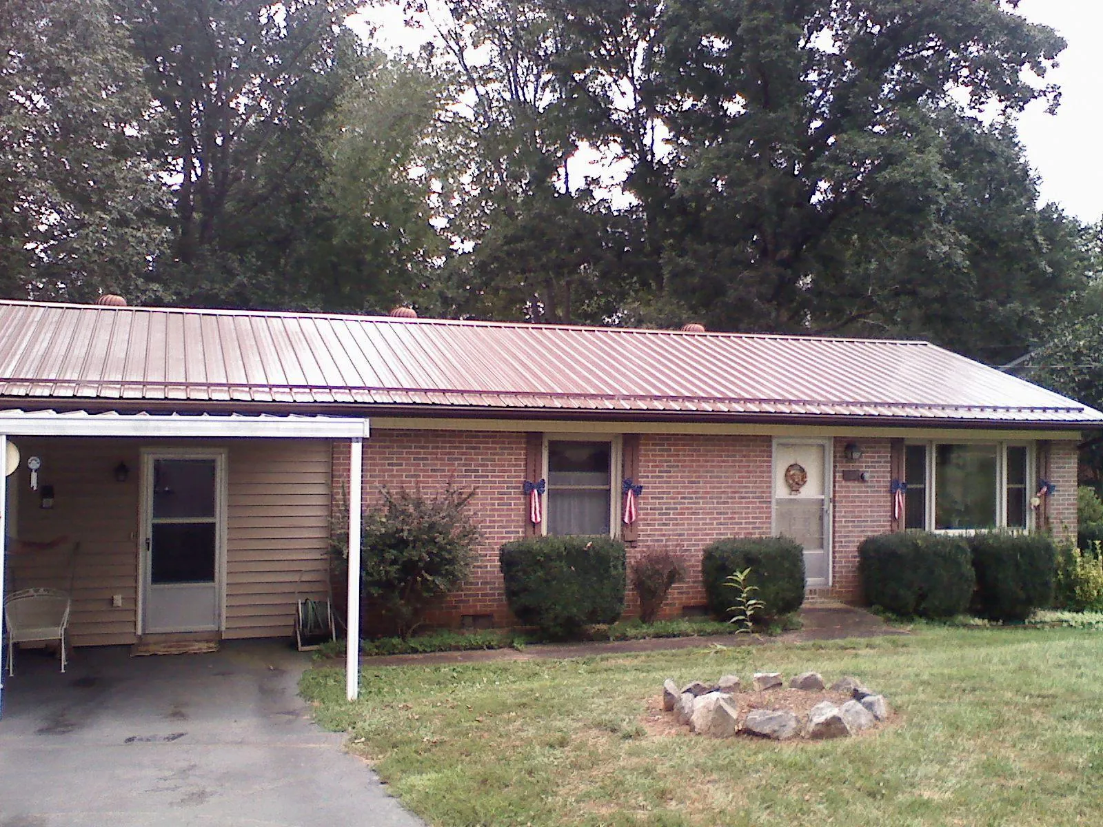 Bronze metal roof and carport on a brick ranch home — Roof Repair work by our crew in Hamel